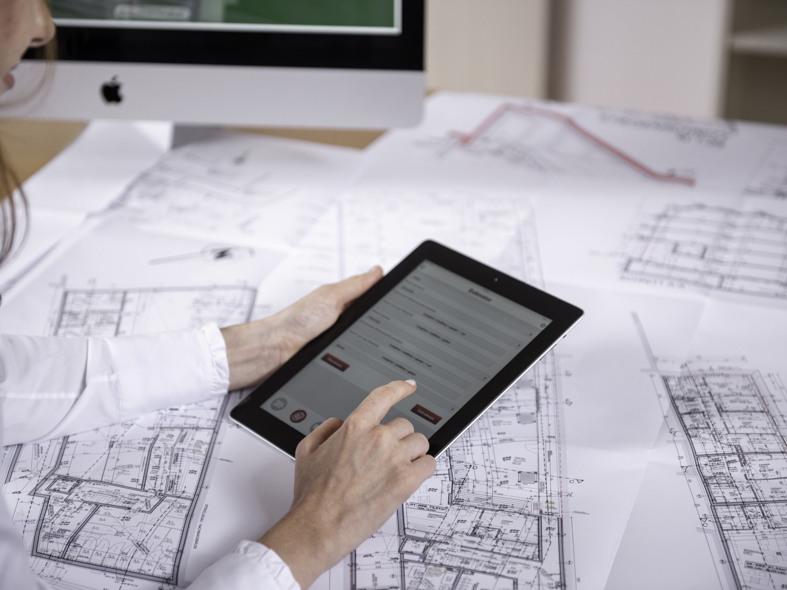 Woman at workplace with blueprint holding tablet computer, Fast Forward Commercial Excellence