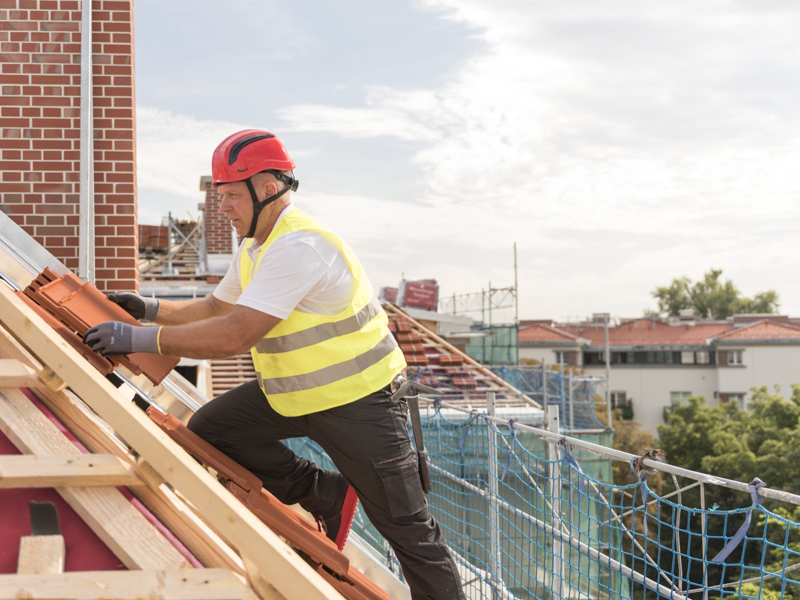 Urban roofers roofer laying roof tiles construction worker wearing hard hat