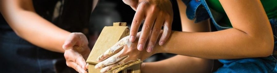 Picture of hands building home from clay
