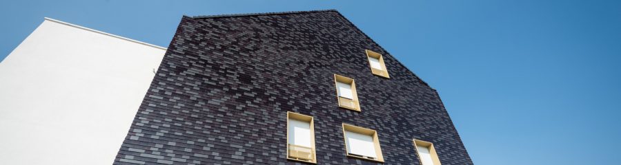 Un bâtiment collectif avec 3 étages. Résidence Florescence. 1 rue Alexandre Fleming Pont à Mousson. Toit koramic tuiles plates 301, antracite et lie de vin émaillé