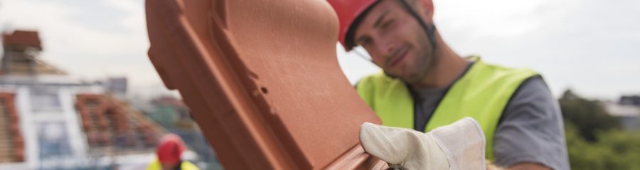 Urban roofers showing product installation roof tiles construction worker wearing hard hat
