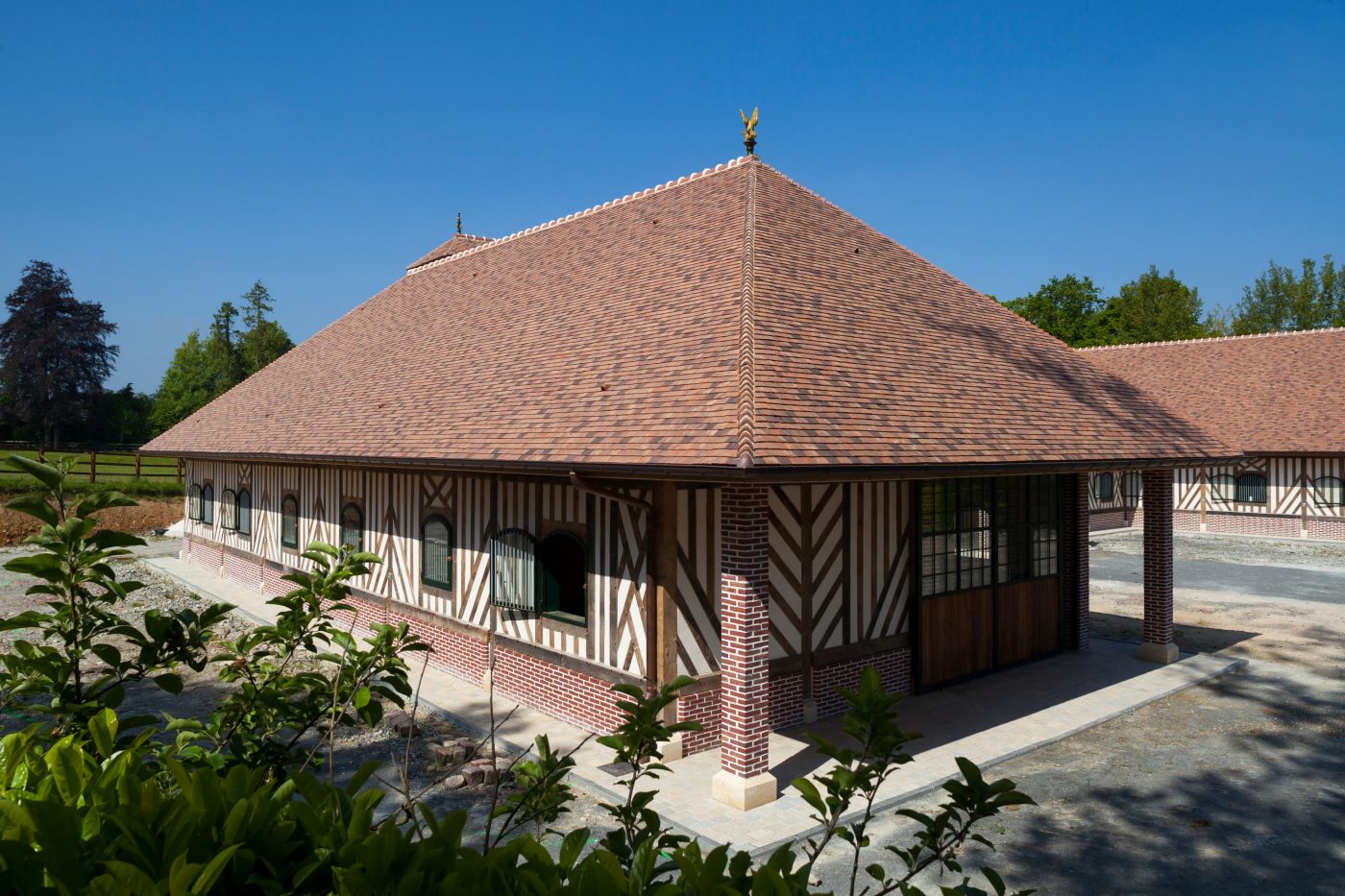 Les écuries Haras des Adelis se trouvent dans un château du 19eme siècle, le château Les Bruyères en Normandie. Haras des Adelis, Château Les Bruyères, Route du Cadran 14340 CAMBREMER. Tuile Koramic Aléonard Saint-Vincent Ambre Foncé (80%), Rouge Obscur (20%).
