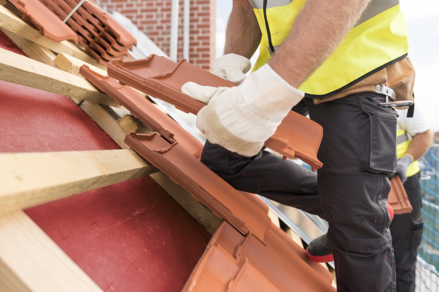Urban roofers roof installation with Alegra roof tiles wearing safety gloves and safety jackets