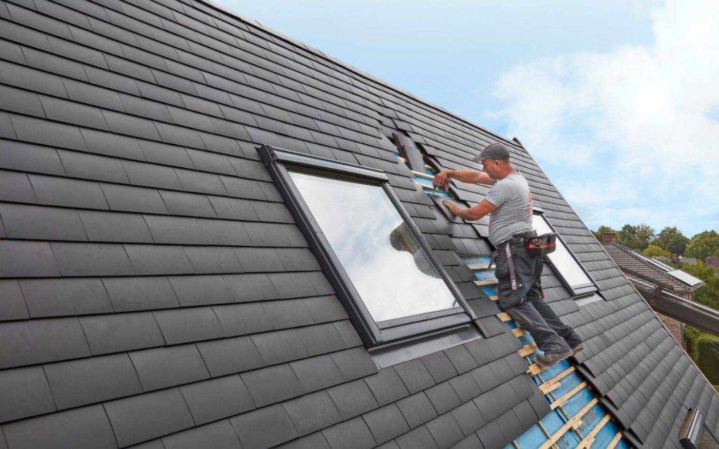 Roofer installing Elfino ceramic roof tiles on a pitched roof