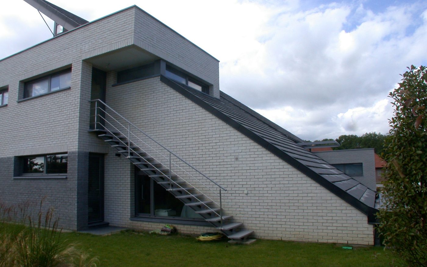 Maison individuelle de 320 m2 avec deux étages. Maison construite selon une architecture bioclimatique (énergie géothermique et récupération de l’eau de pluie). 59710 MERIGNIES. Mise en oeuvre toiture. Tuile Koramic Actua Anthracite.