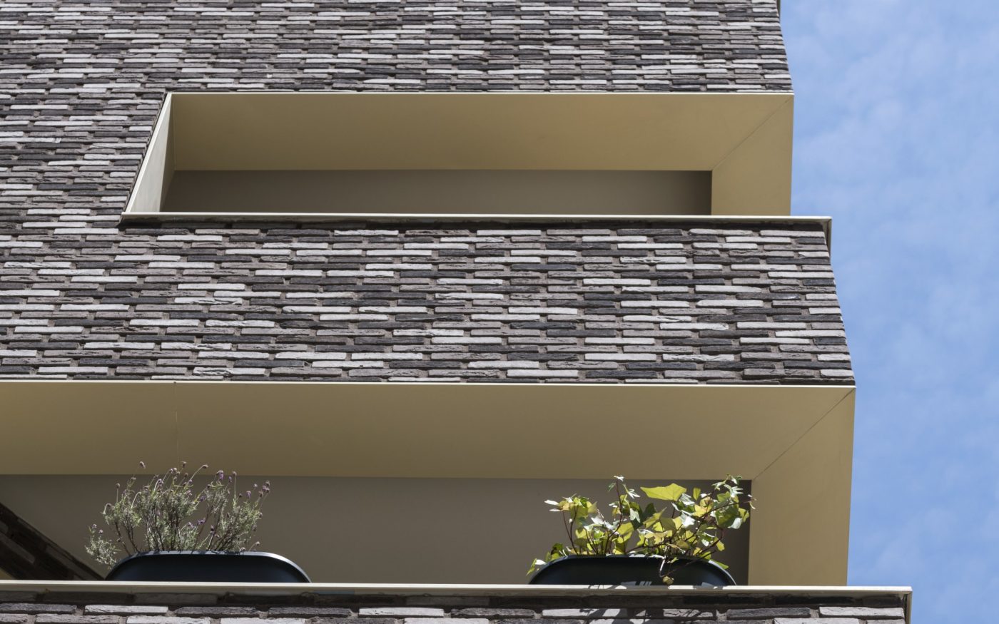 Immeuble avec des appartements et des maisons individuelles. Bâtiment avec des couleurs chaudes et un toit vert.  Immeuble Allure, 66 rue Mstislav Rostropovitch 75017 PARIS. Brique Terca KESS and Ligne Moulée Main Elmore, Forum Cromo, Nero Zwart Mangaan.