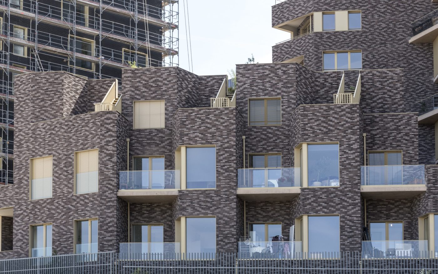 Immeuble avec des appartements et des maisons individuelles. Bâtiment avec des couleurs chaudes et un toit vert.  Immeuble Allure, 66 rue Mstislav Rostropovitch 75017 PARIS. Brique Terca KESS and Ligne Moulée Main Elmore, Forum Cromo, Nero Zwart Mangaan.