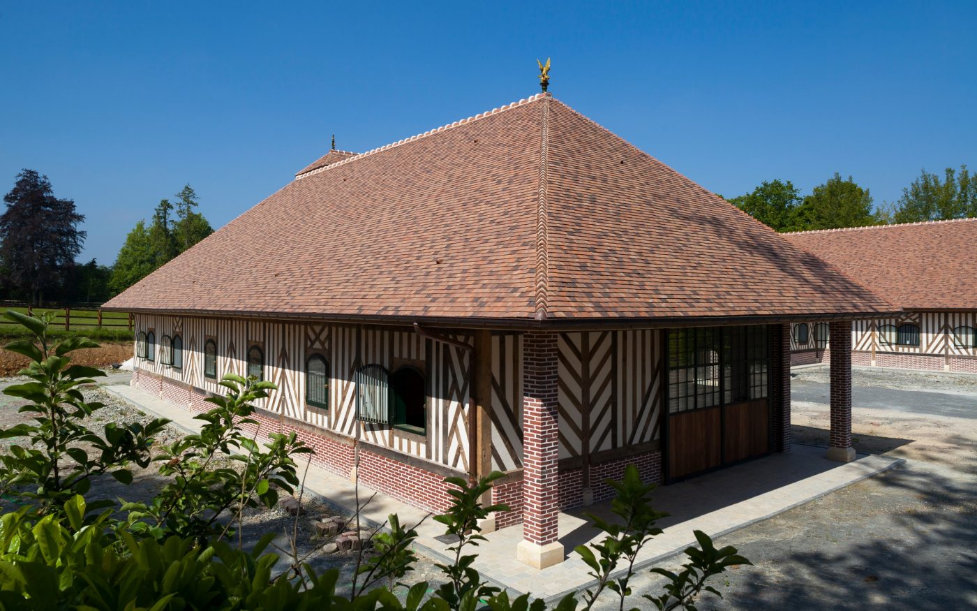 Les écuries Haras des Adelis se trouvent dans un château du 19eme siècle, le château Les Bruyères en Normandie. Haras des Adelis, Château Les Bruyères, Route du Cadran 14340 CAMBREMER. Tuile Koramic Aléonard Saint-Vincent Ambre Foncé (80%), Rouge Obscur (20%).