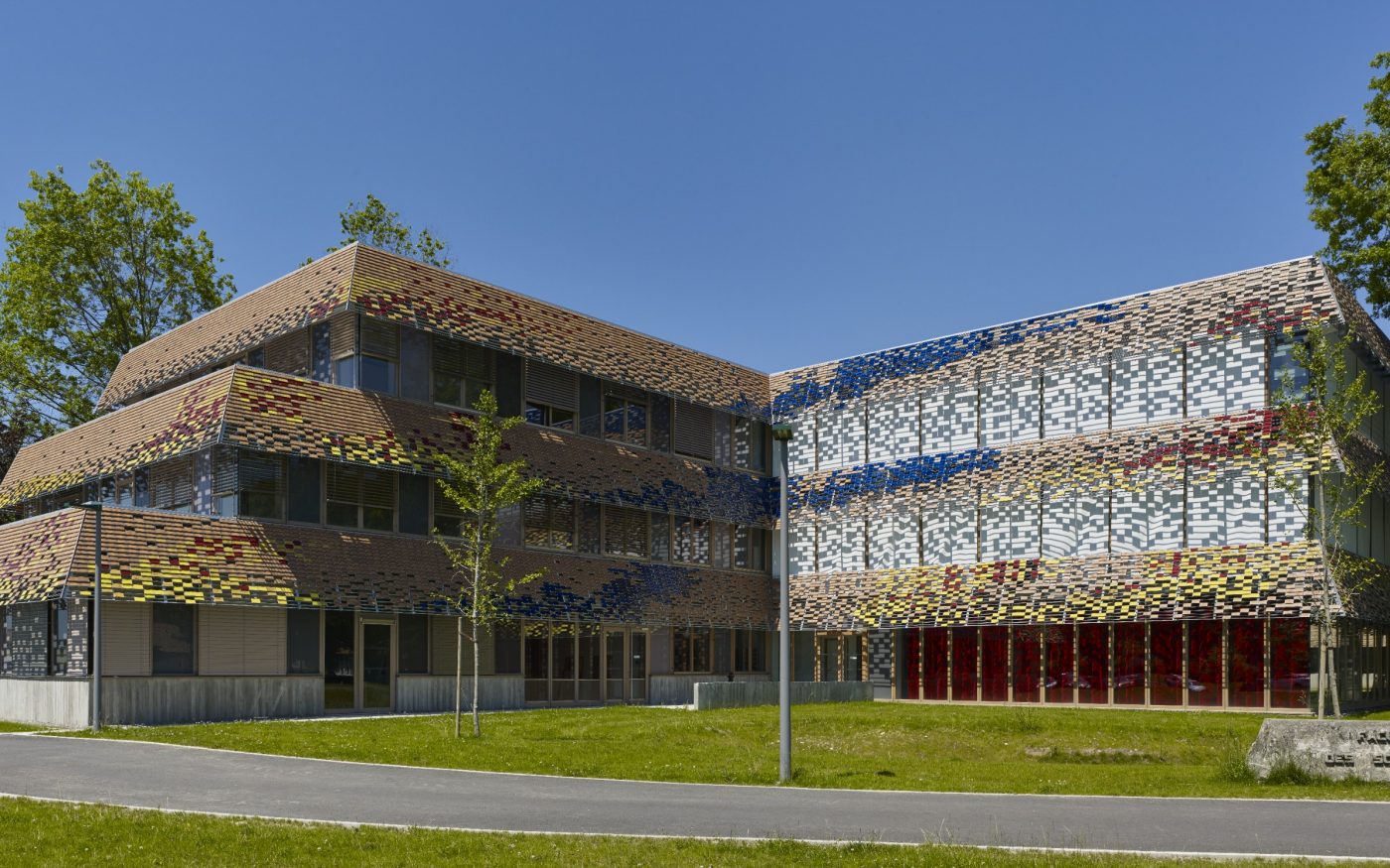 Extension du pôle recherche de l'université de Pau. Surface : 3600 m2. Certifications BBC et RT 2012. 25 500 tuiles émaillées Koramic : jaune, rouge et bleu. Gagnant du Grand prix "La Tuile Terre Cuite Architendance" dans la catégorie bâtiment tertiaire.