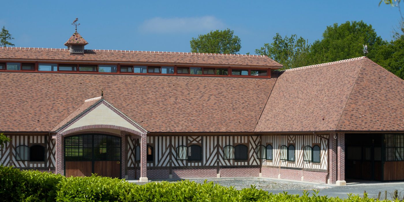 Les écuries Haras des Adelis se trouvent dans un château du 19eme siècle, le château Les Bruyères en Normandie. Haras des Adelis, Château Les Bruyères, Route du Cadran 14340 CAMBREMER. Tuile Koramic Aléonard Saint-Vincent Ambre Foncé (80%), Rouge Obscur (20%).