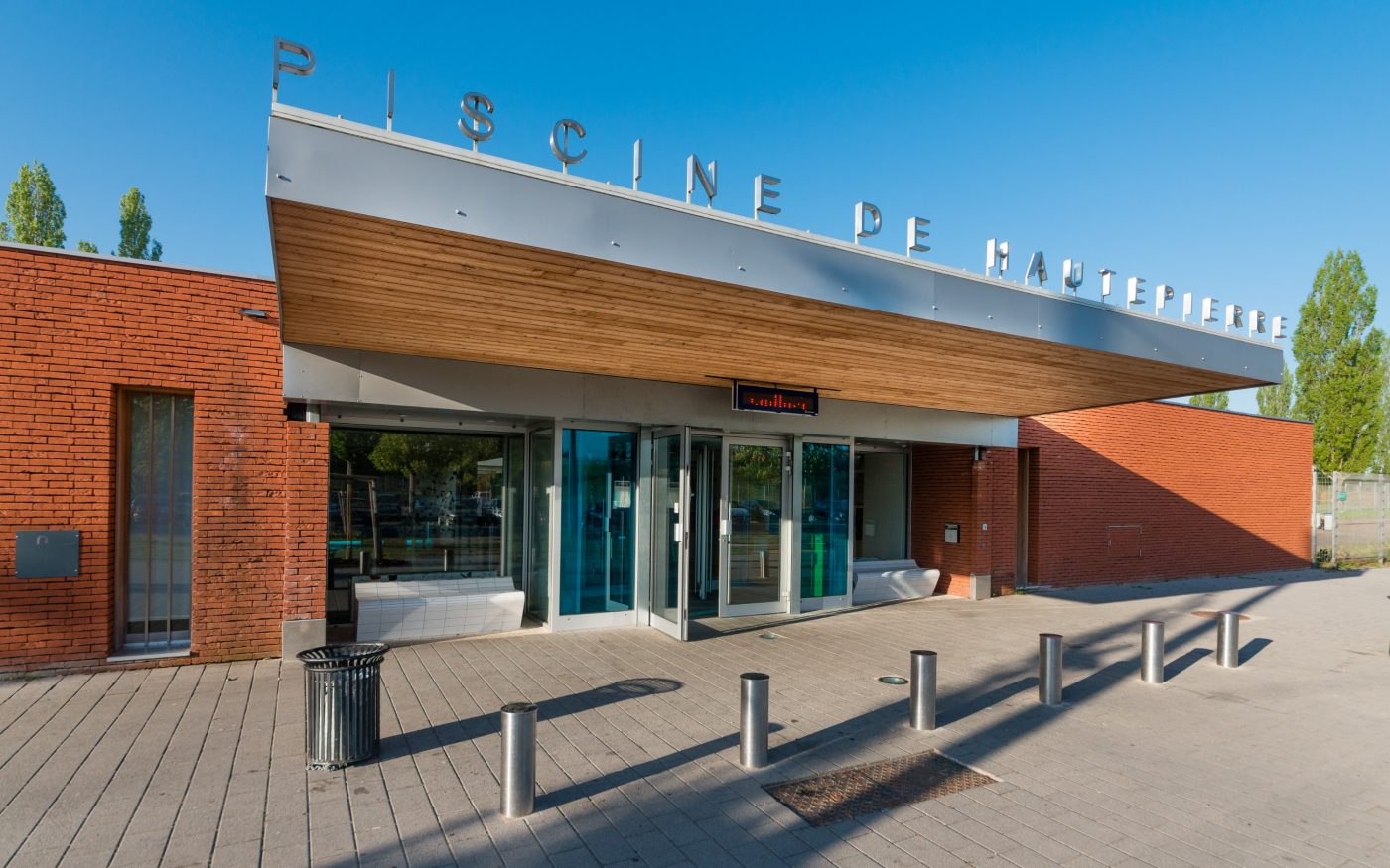 Bâtiment avec un seul étage. Piscine municipale de Hautepierre, rue Baden Powell 67200 STRASBOURG. Brique Terca Ligne Moulée Main Forum rojo. Pose en joints vifs. Mise en œuvre bardage.