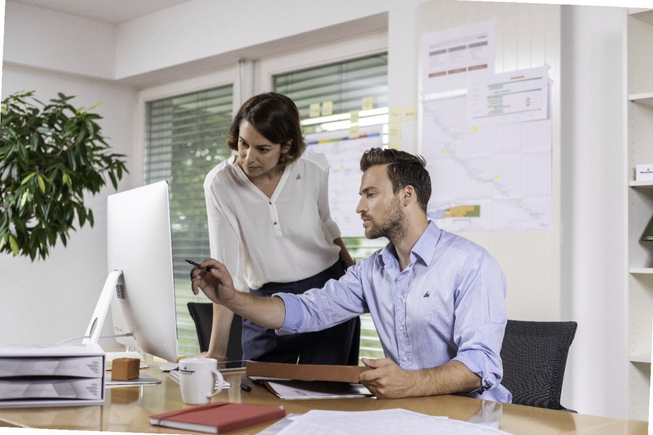 Male and female project manager collaborating in front of computer screen at office