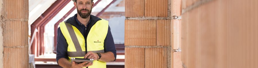 Product manager standing in attic under renovation holding iPad