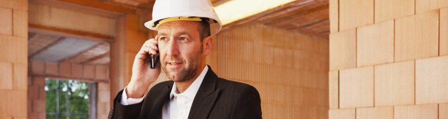 Building professional with mobile phone and blueprint inside building-shell