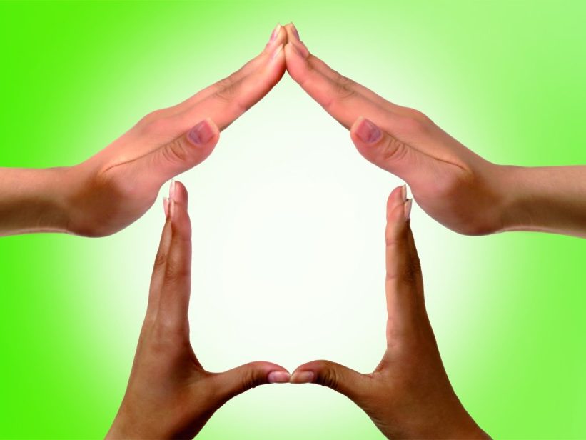 Conceptual symbol home made from black and white hands isolated over white background