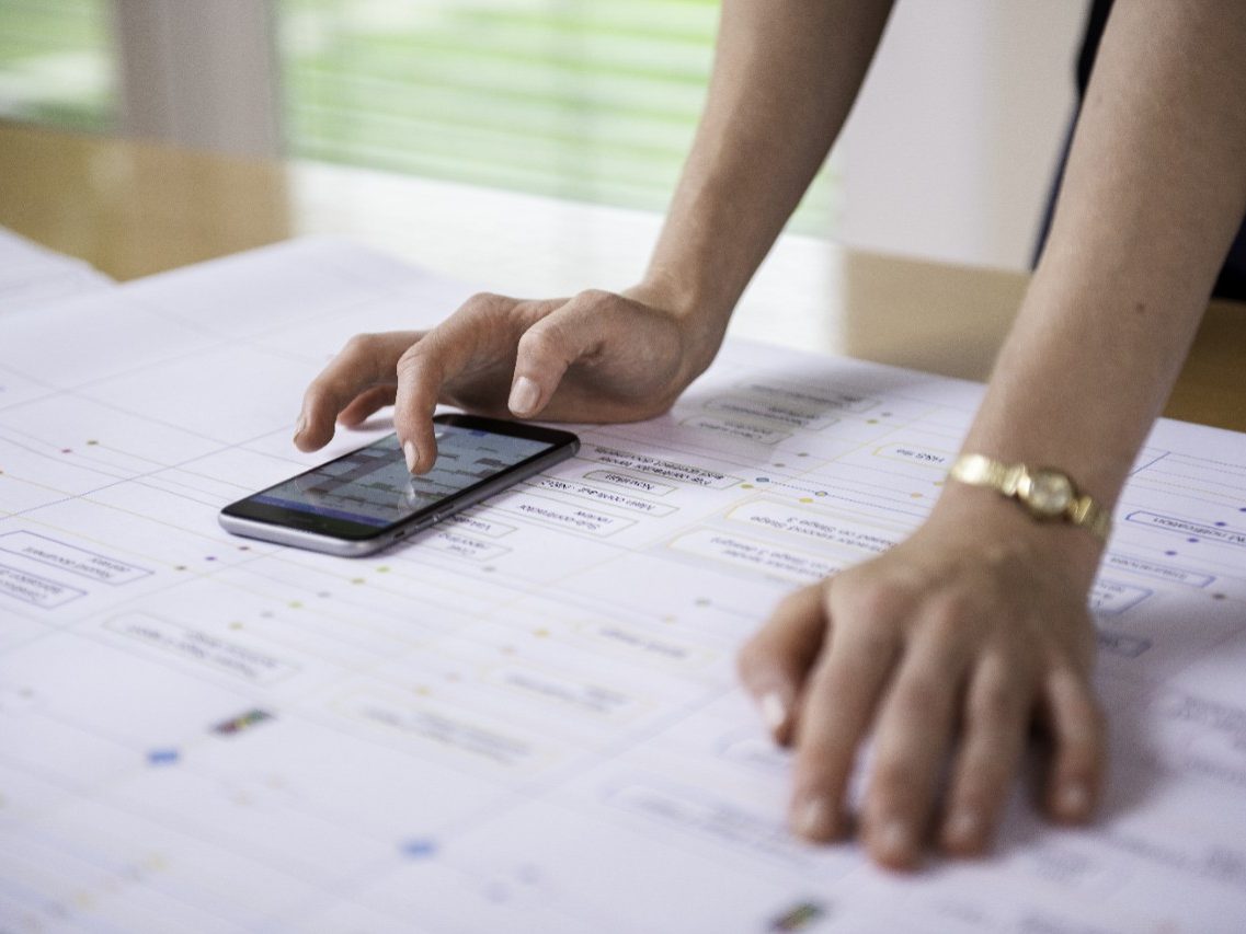 Project manager aligning project process map with calendar app on mobile phone