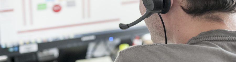 Young man sitting in front of computer screen with headset