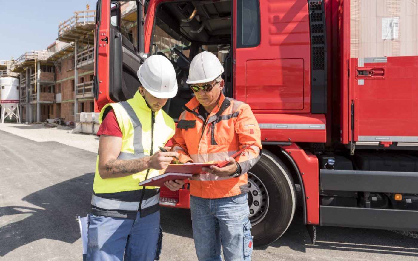 Construction worker signs delivery slip