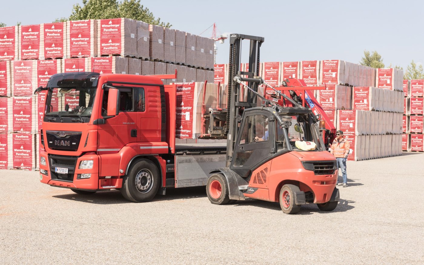 Forklift loads clay block pallets onto truck at stockyard
