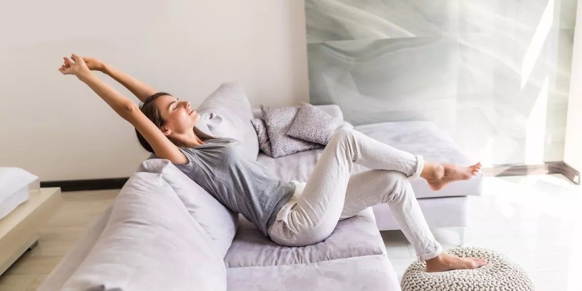 Femme qui s'étire sur un canapé